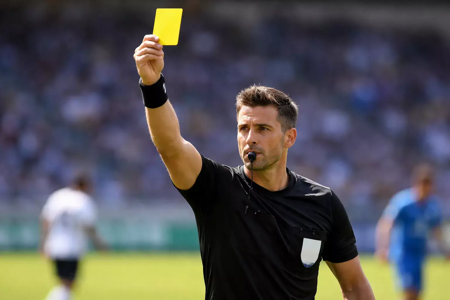 Scheidsrechter houdt gele kaart omhoog